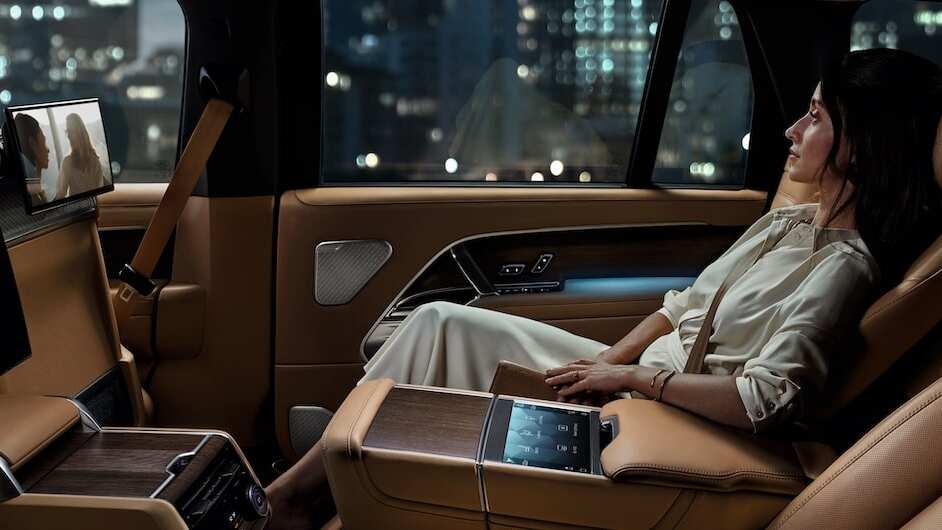Woman reclined in the New Range Rover watching TV
